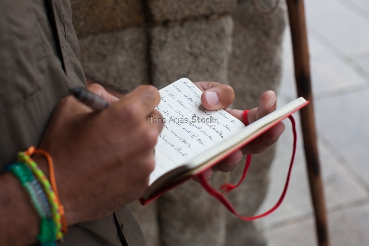 Peregrino escribiendo en la plaza del Obradoiro, Santiago de Com